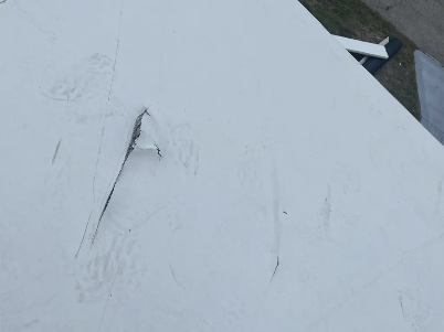 Cracked white surface with a chipped area and dark triangular opening at the edge