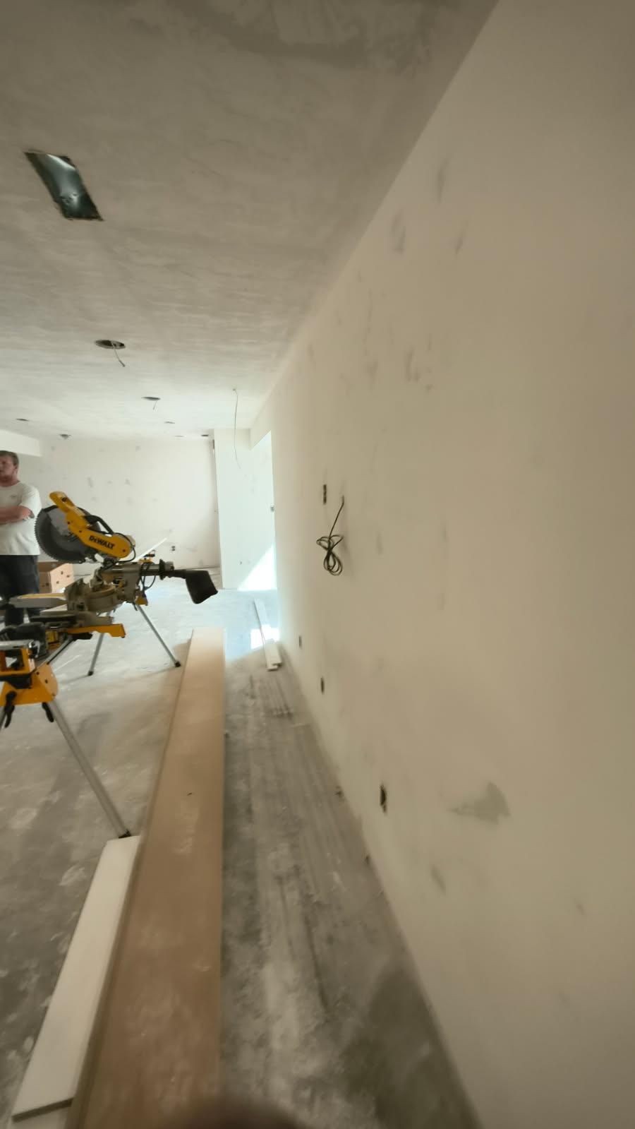 Long hallway under renovation with tools and materials along the left wall