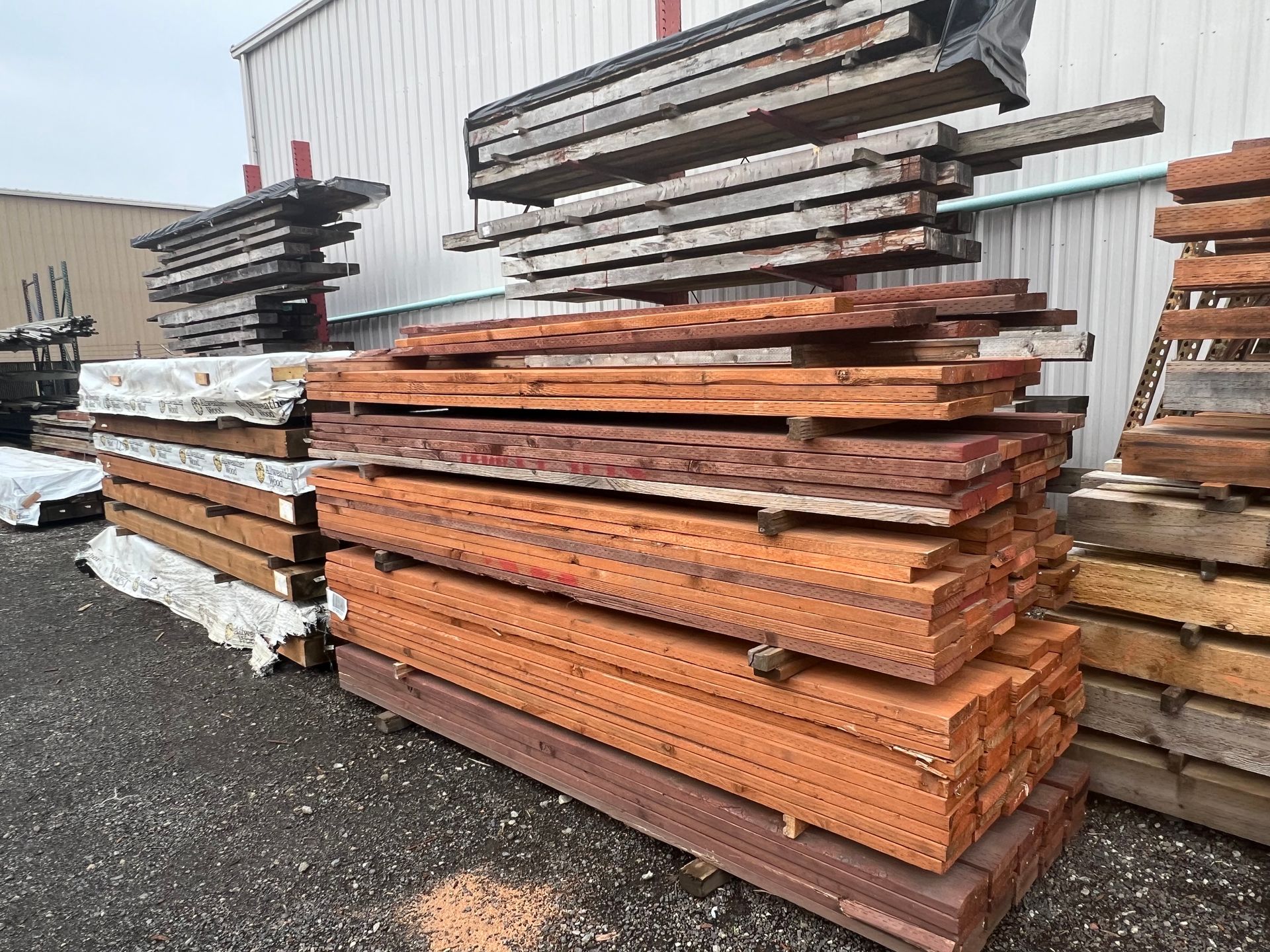 A pile of wood is stacked on top of each other in front of a building.