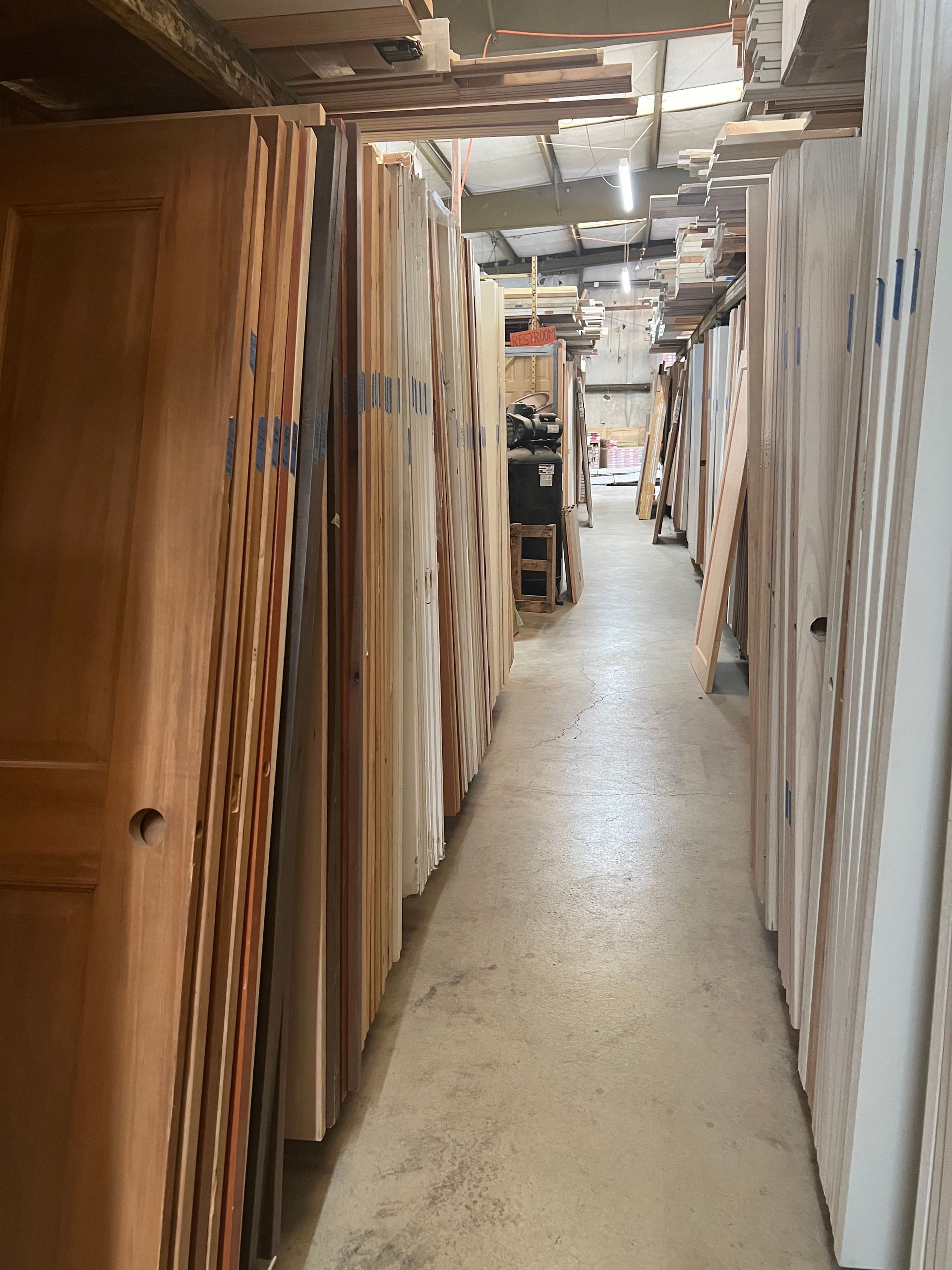 A long hallway filled with lots of wooden doors.