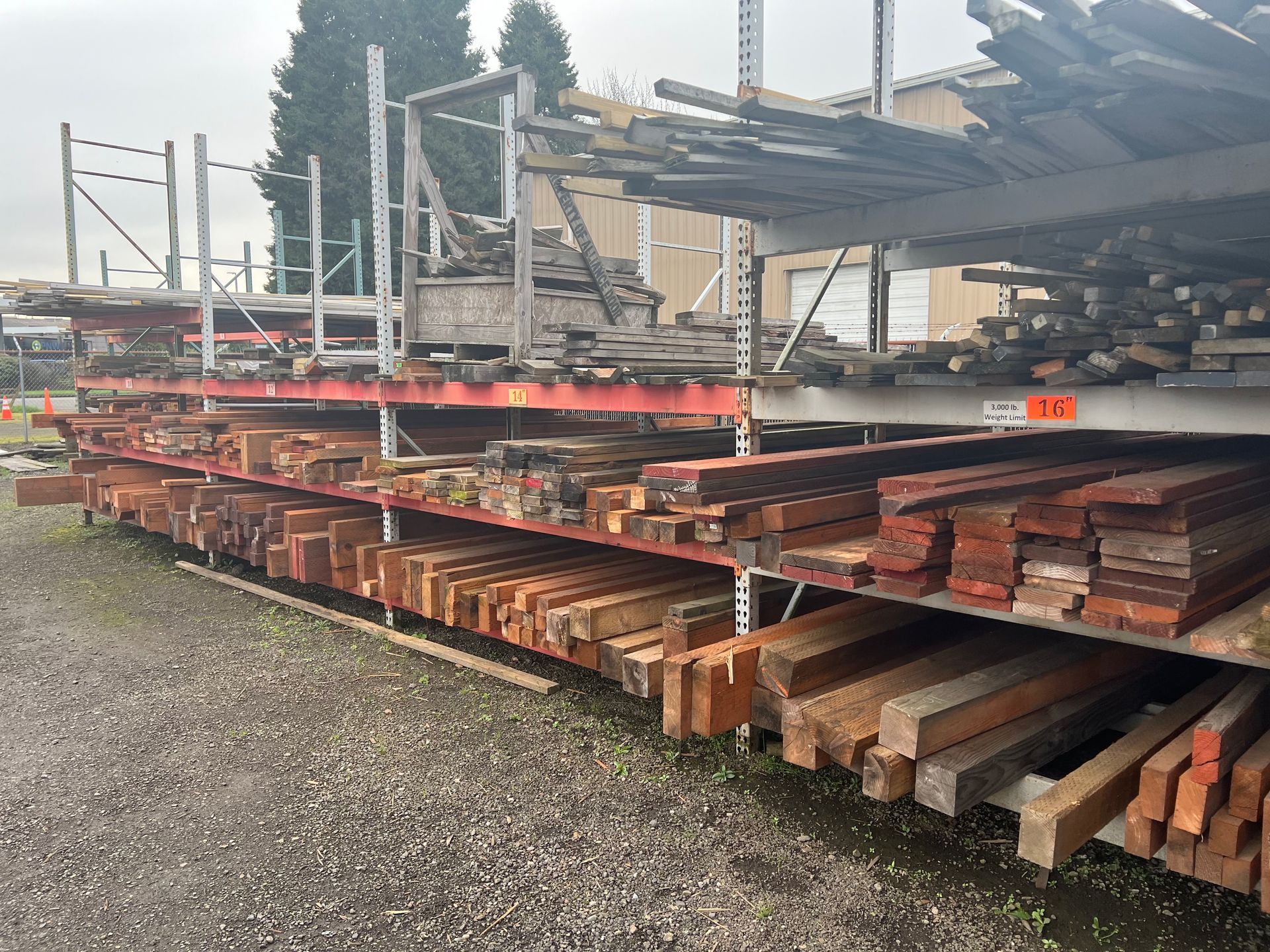 A lot of wood is stacked on shelves in a warehouse.