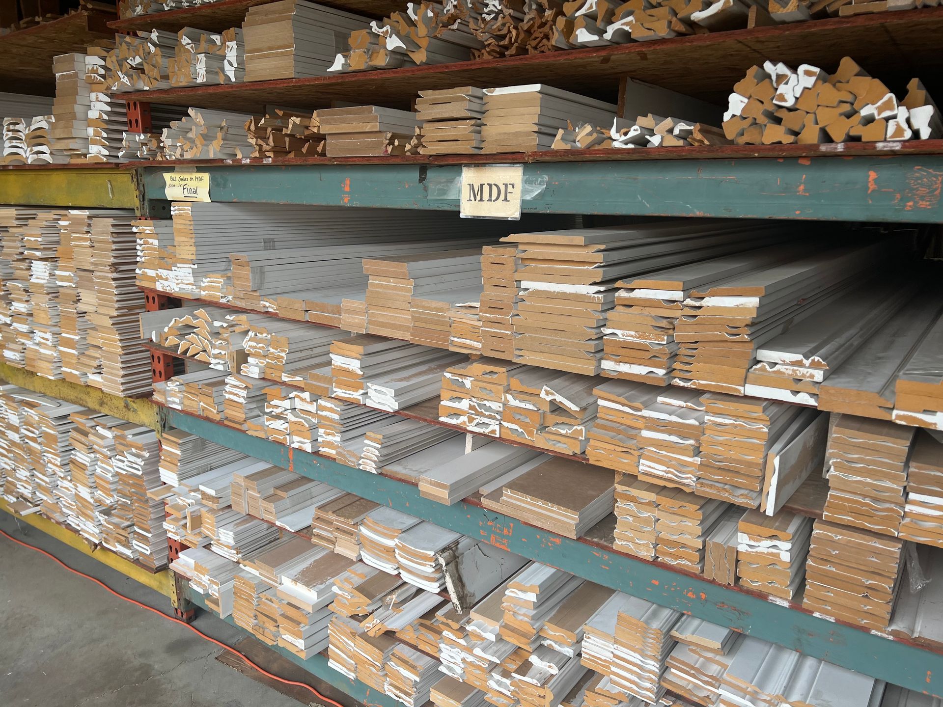A warehouse filled with lots of wood and a sign that says MDF.