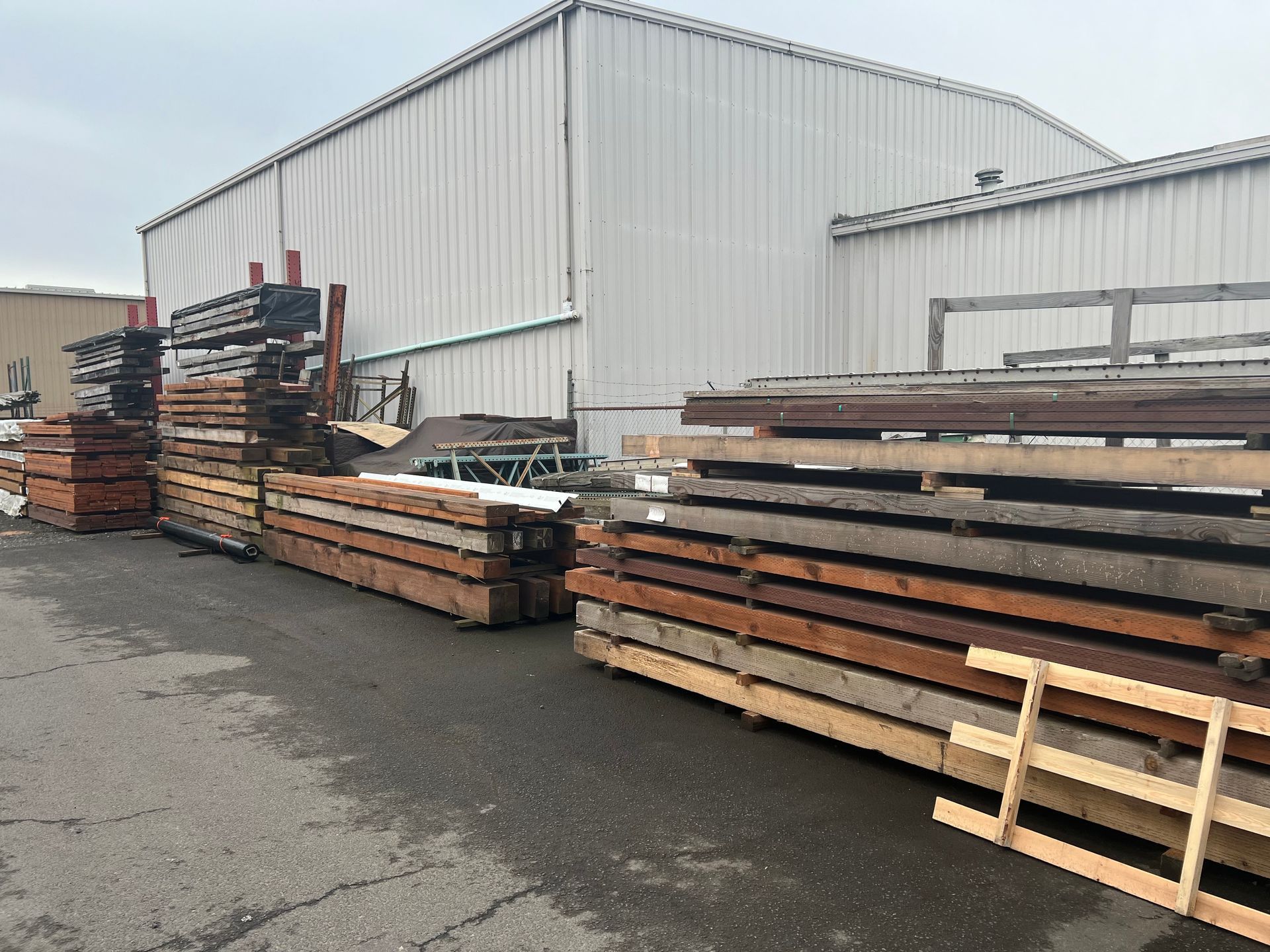 A bunch of wooden pallets are stacked on top of each other in front of a building.
