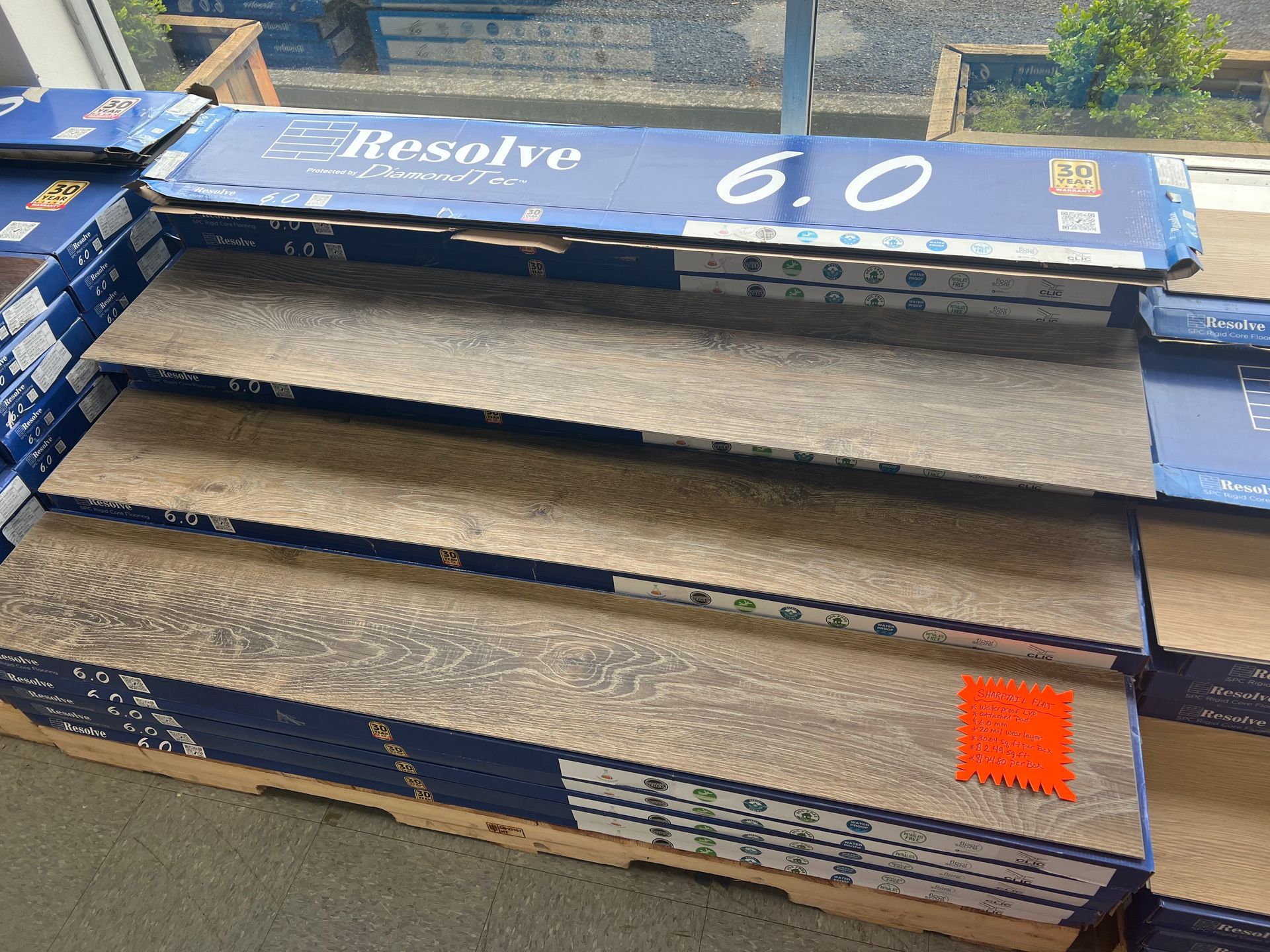 A bunch of boxes of flooring are stacked on top of each other.