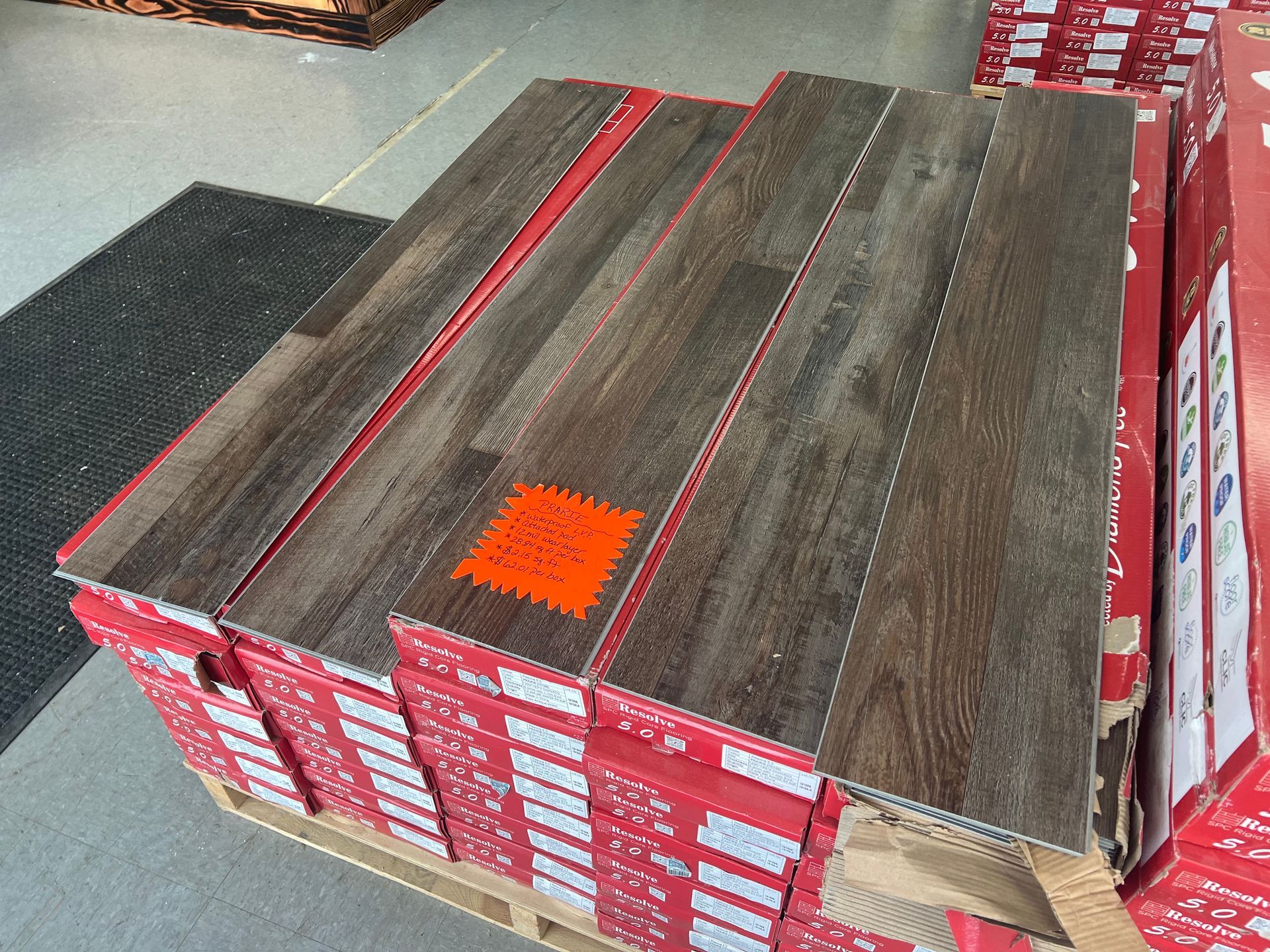 A pallet of wooden flooring with an orange sticker on it.