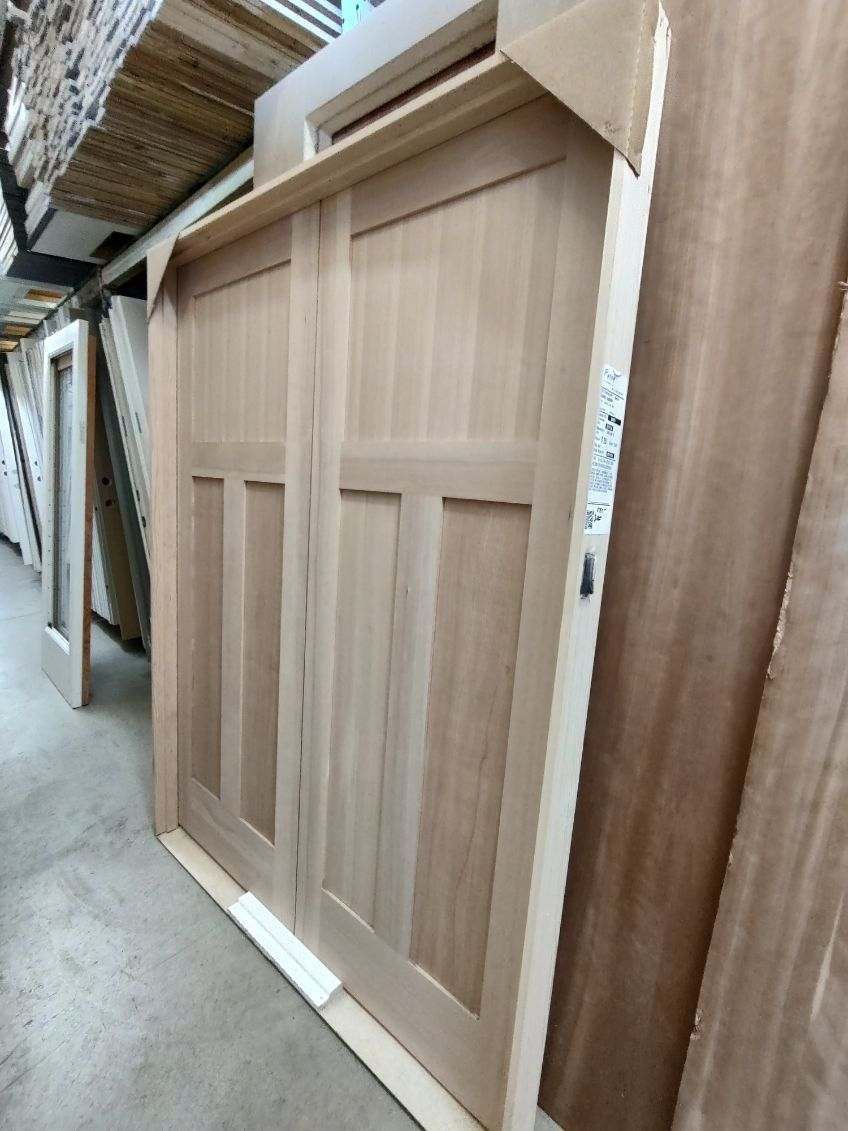 A wooden door is sitting on the floor in a warehouse.