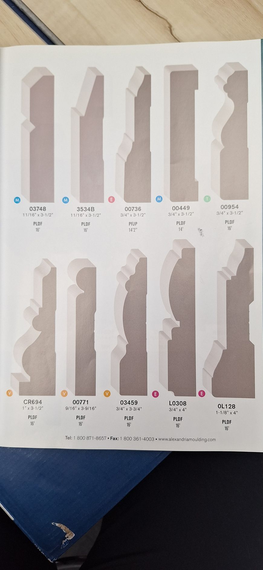 A catalog page showing ten different wood baseboard moulding profiles, each labeled with a letter and dimensions