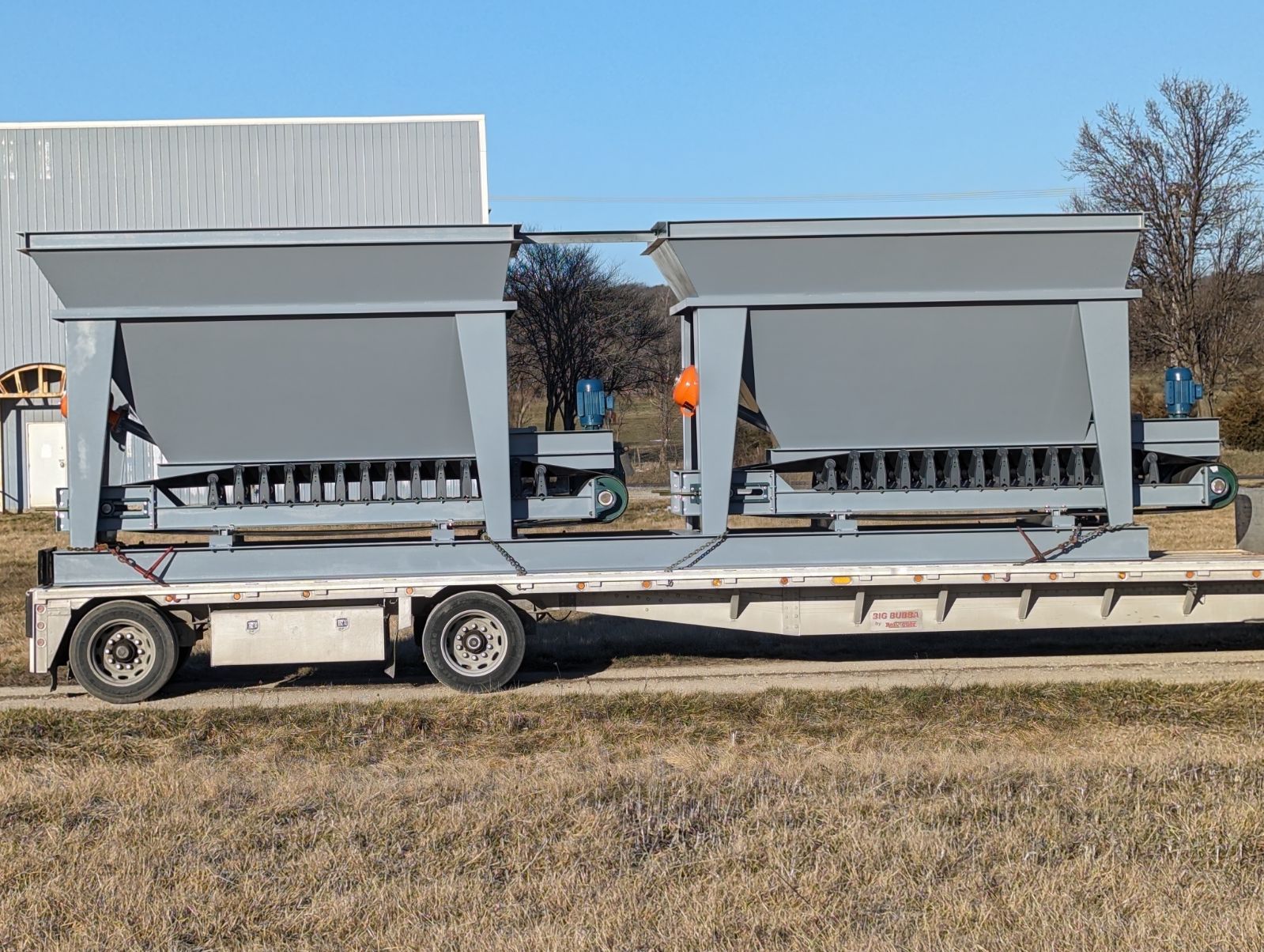 A truck is carrying a large machine on a trailer.