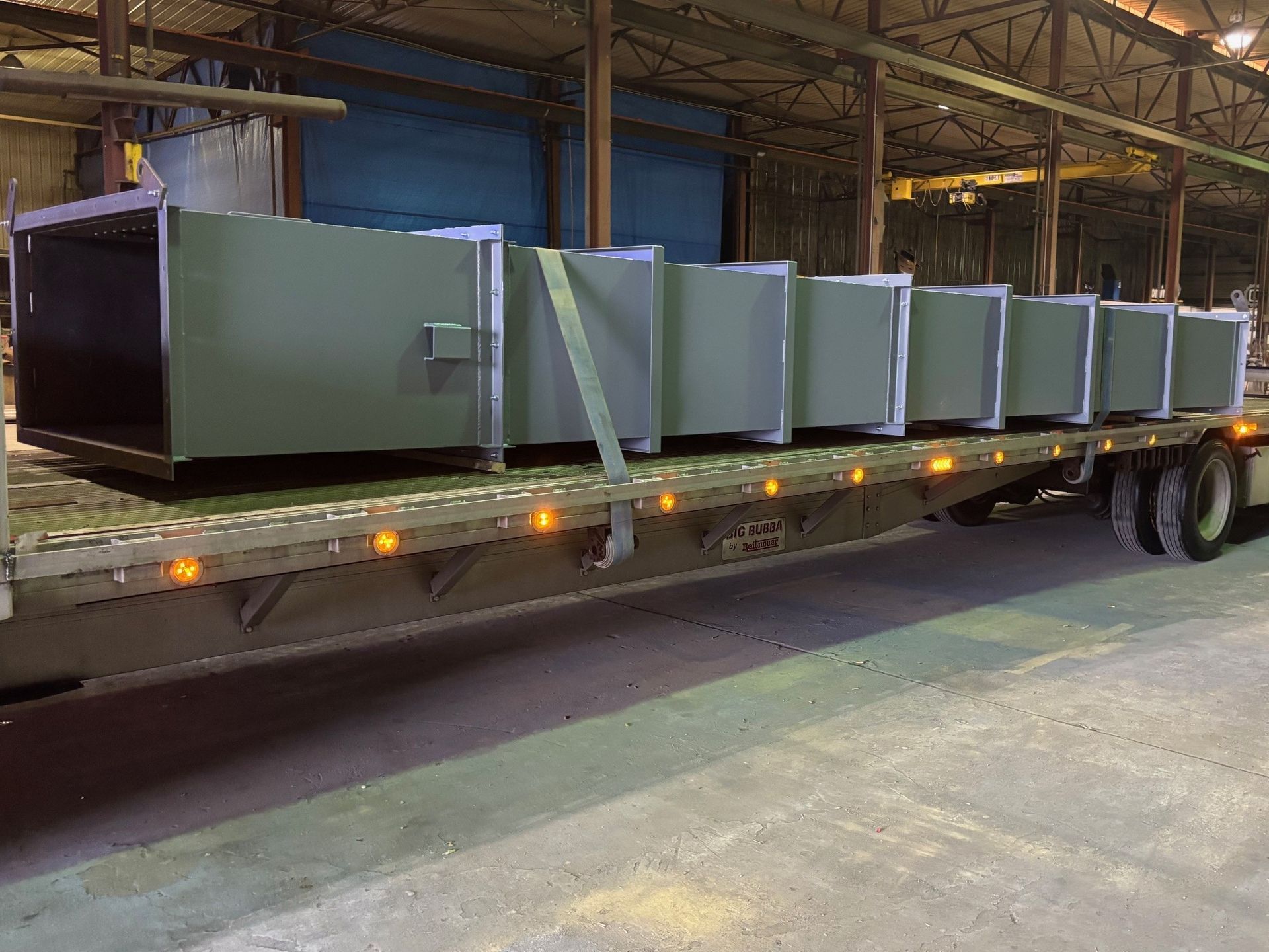 A large metal grate is sitting on top of a concrete floor.