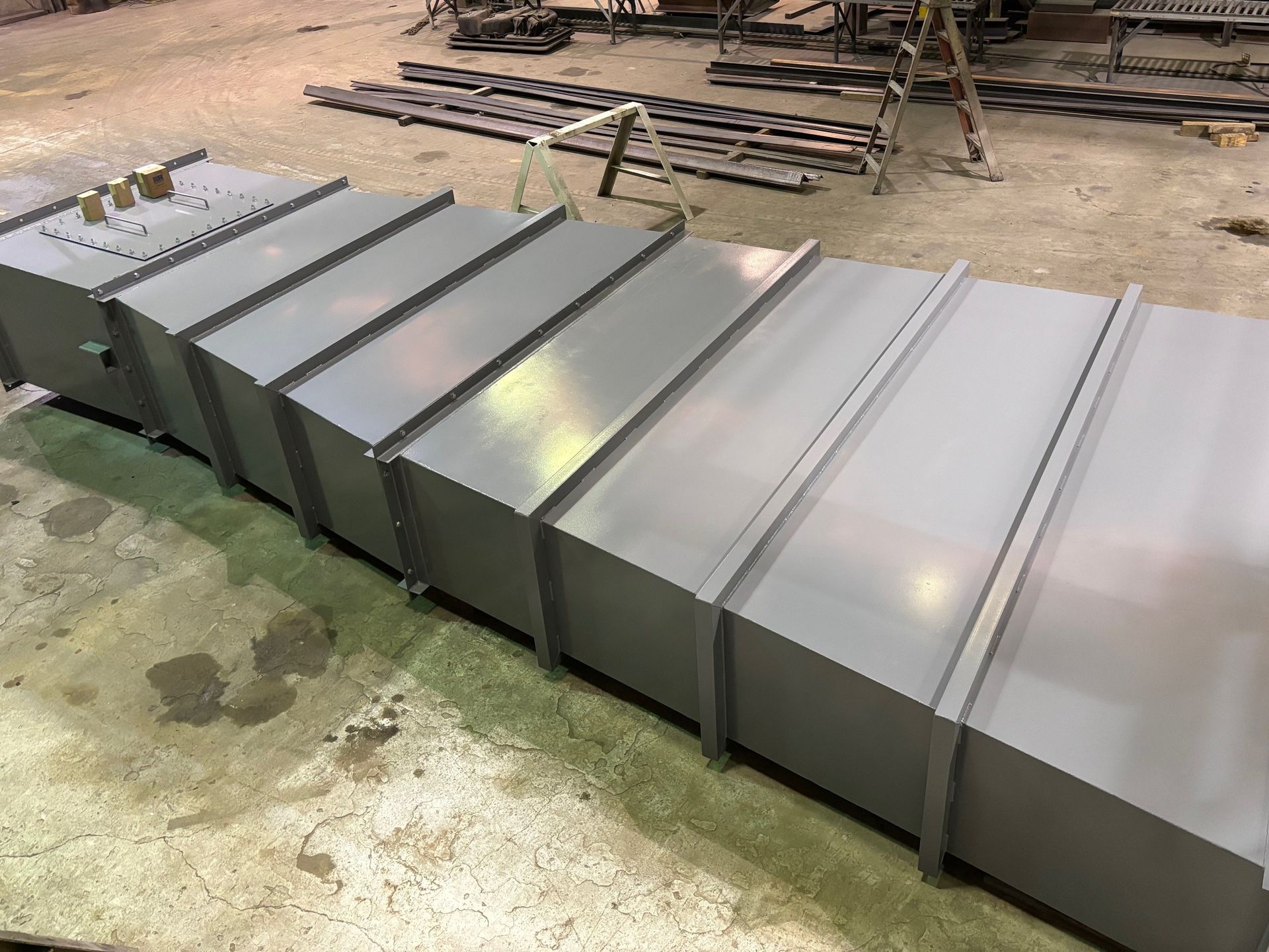 A row of metal boxes sitting on top of a cement floor.