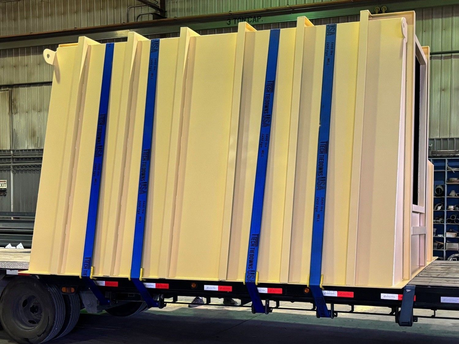 A large container is sitting on top of a trailer.