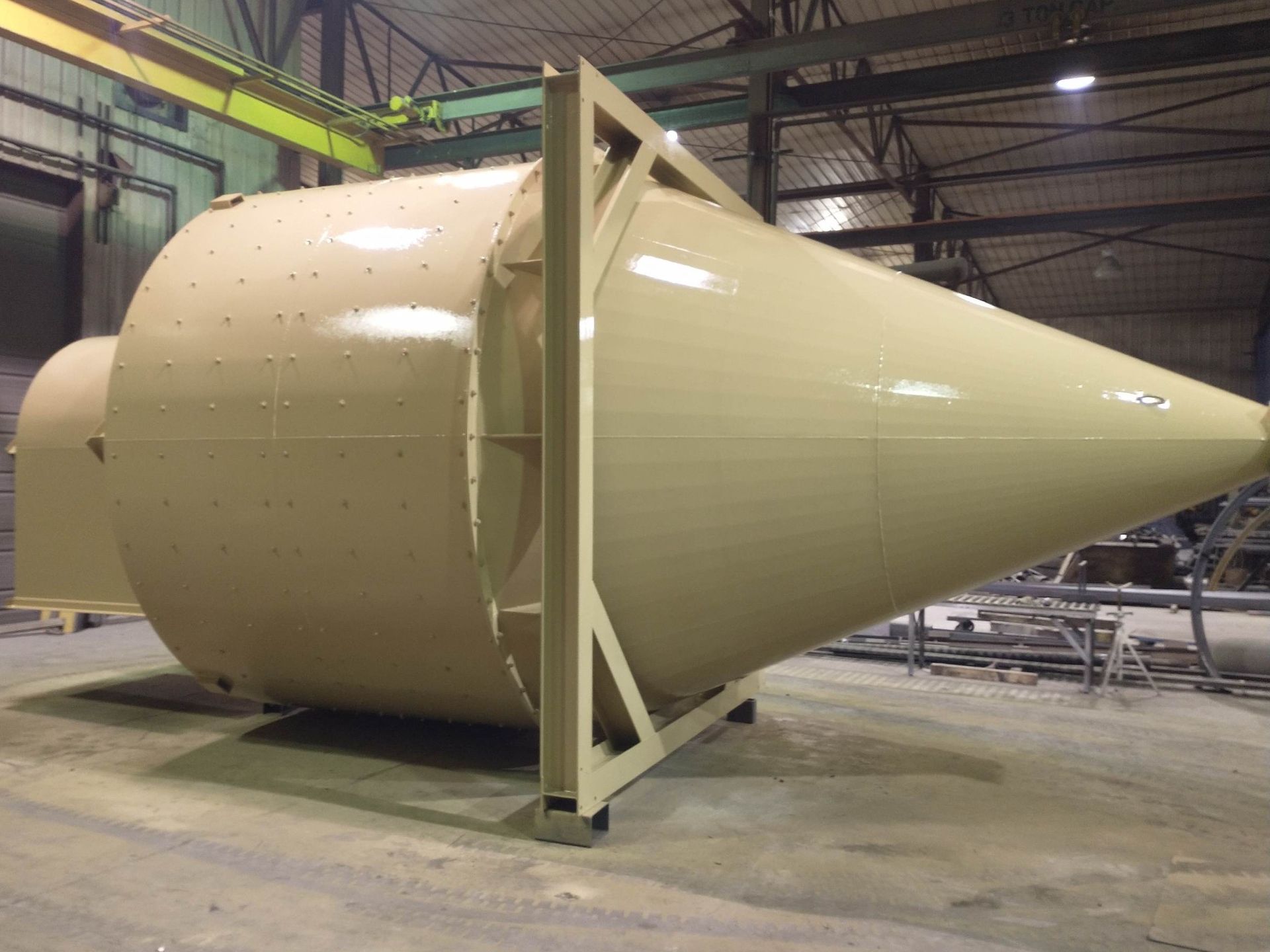A large cone shaped object is sitting in a warehouse.