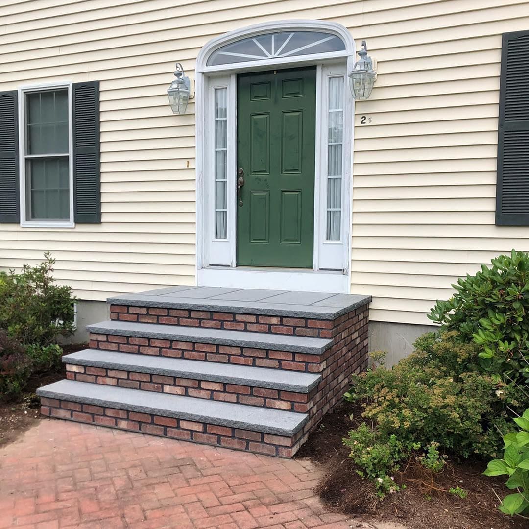 A house with a green door and brick steps