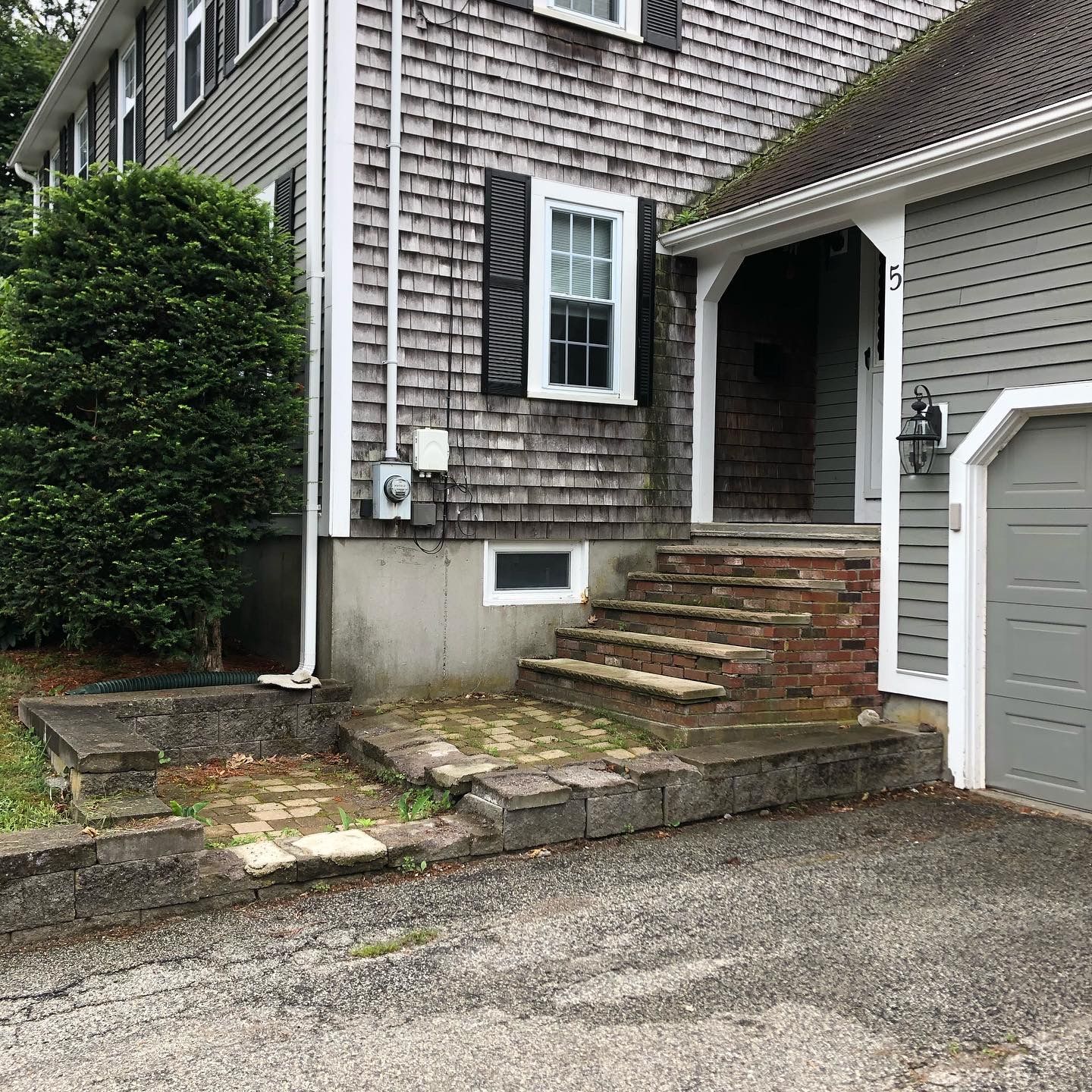 A house with stairs leading up to the front door and a garage.