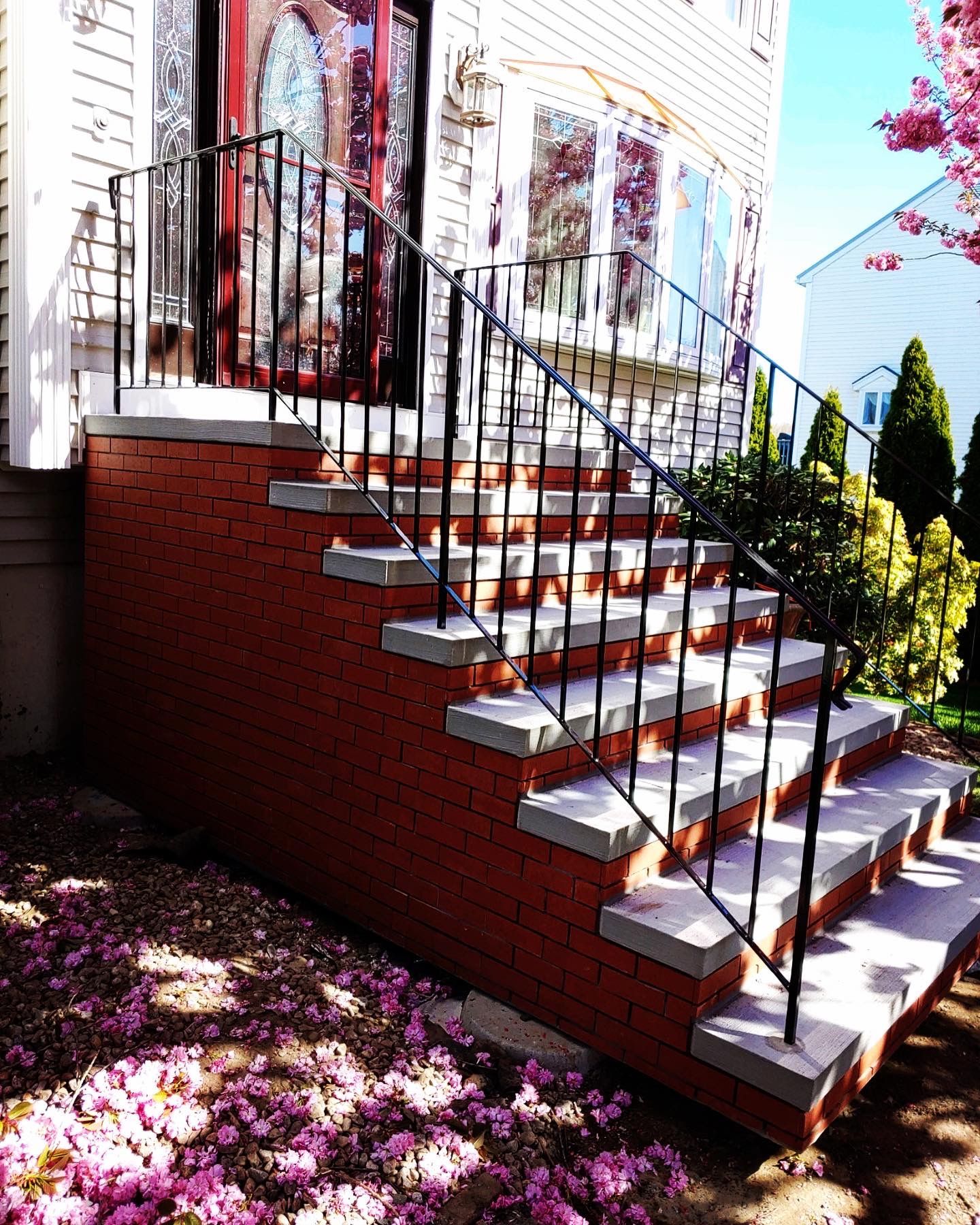A set of stairs leading up to a house with a wrought iron railing