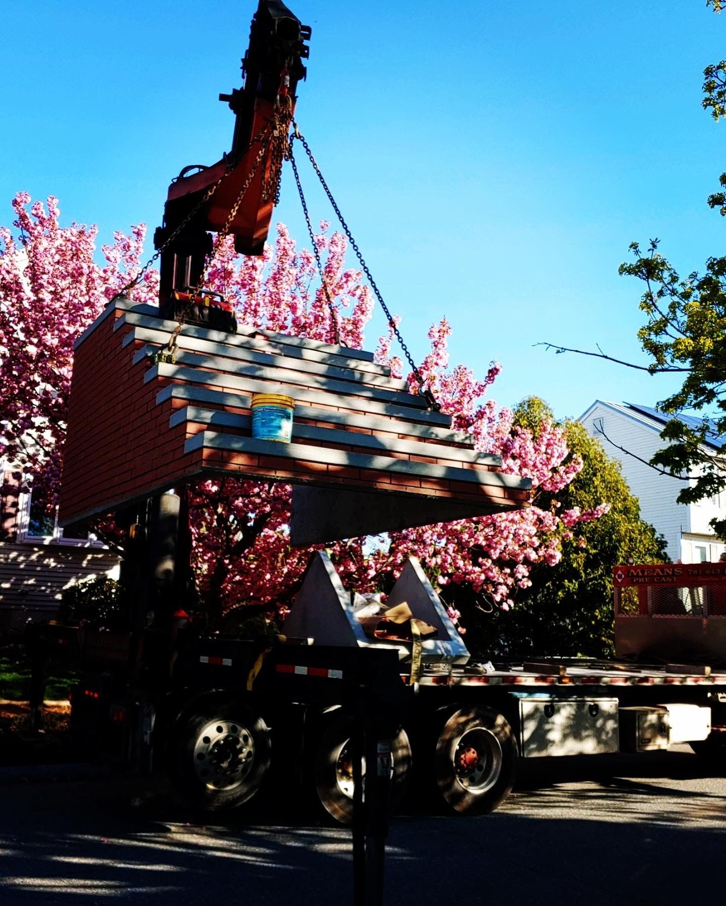 A large piece of wood is being lifted by a crane