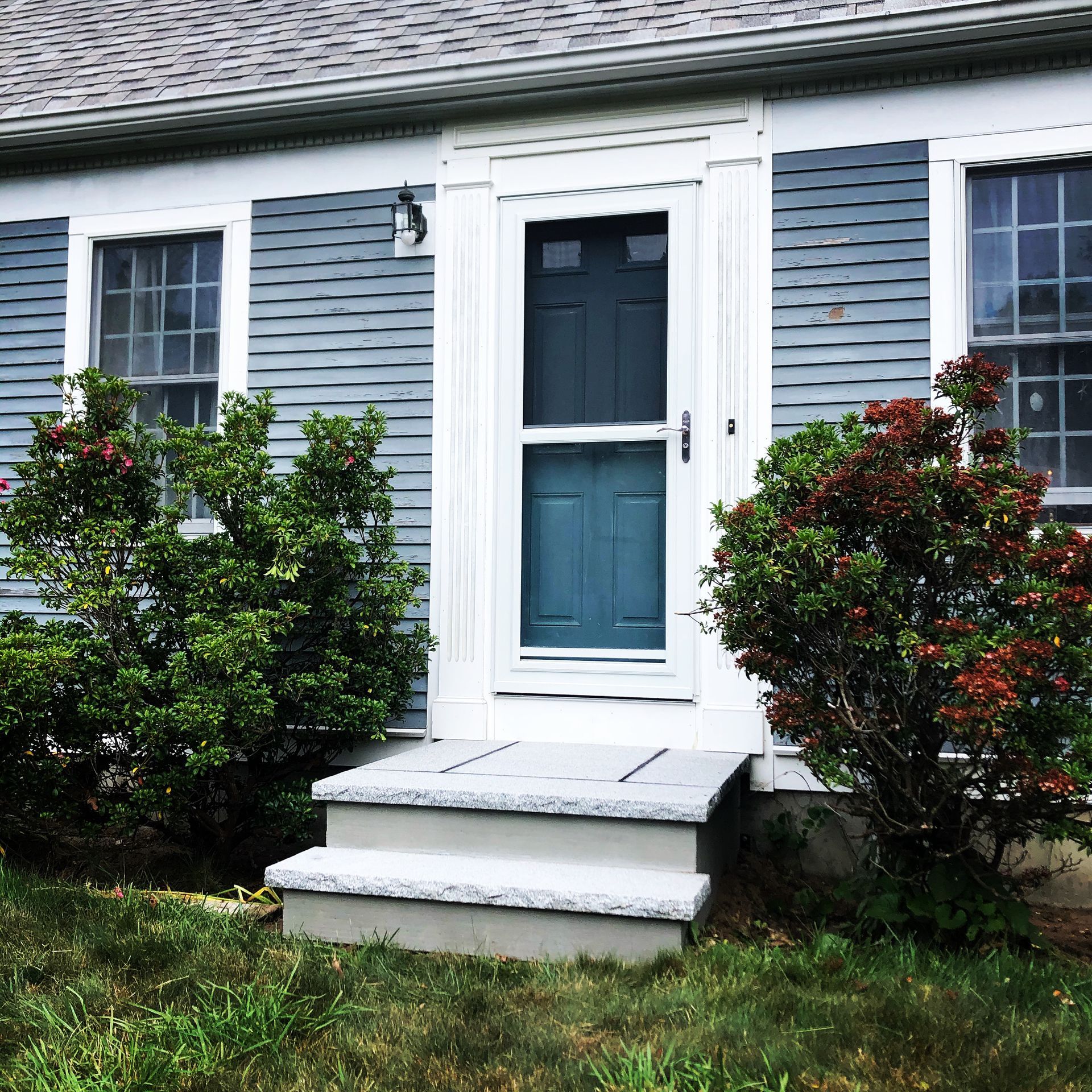 A blue house with white trim and a blue door