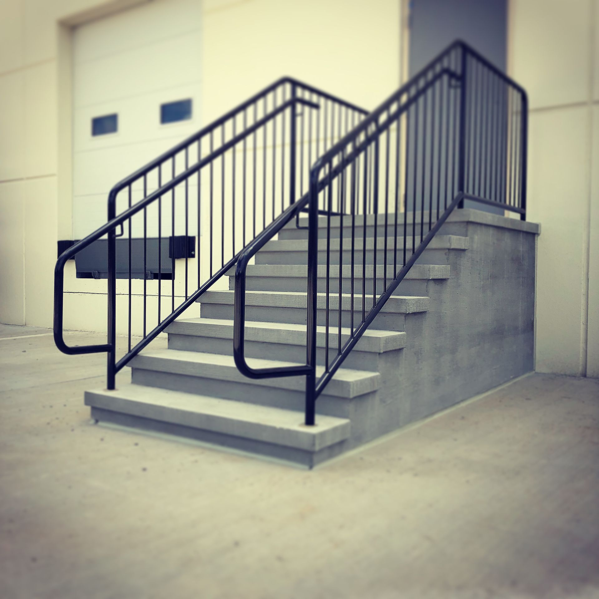 A set of concrete stairs with a metal railing