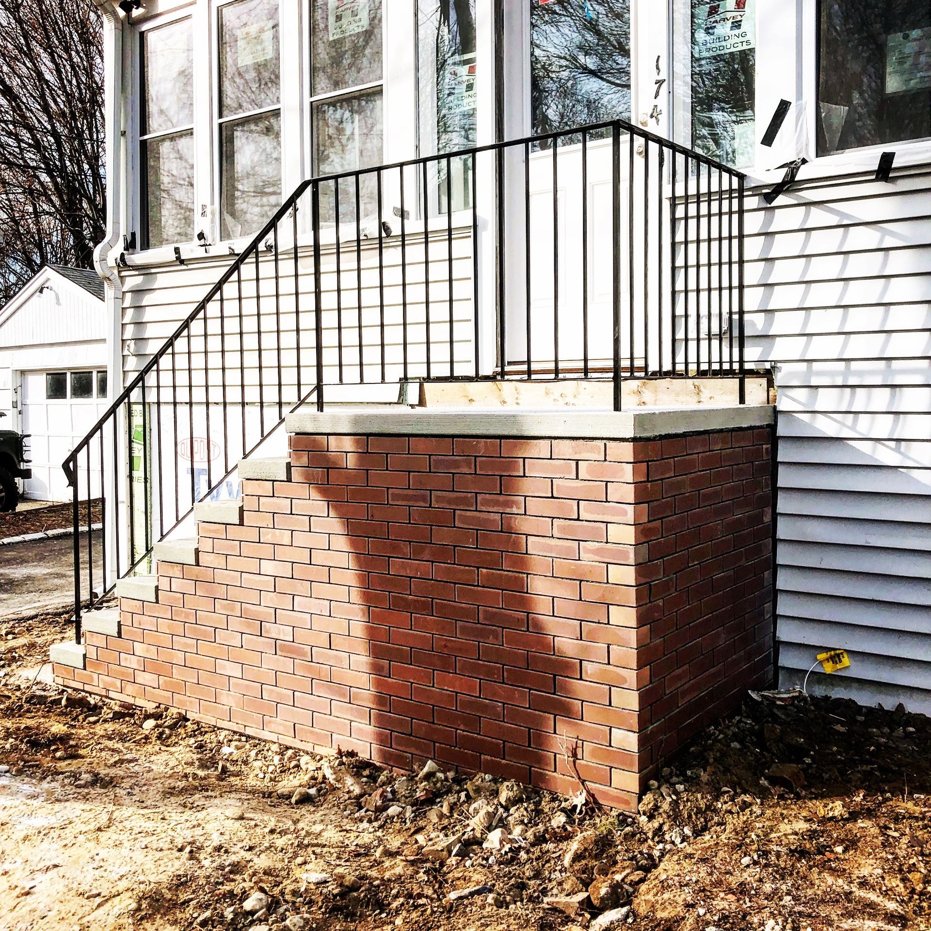 A white house with a brick porch and stairs