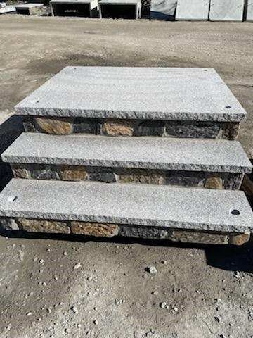A set of stone steps sitting on top of a dirt field.
