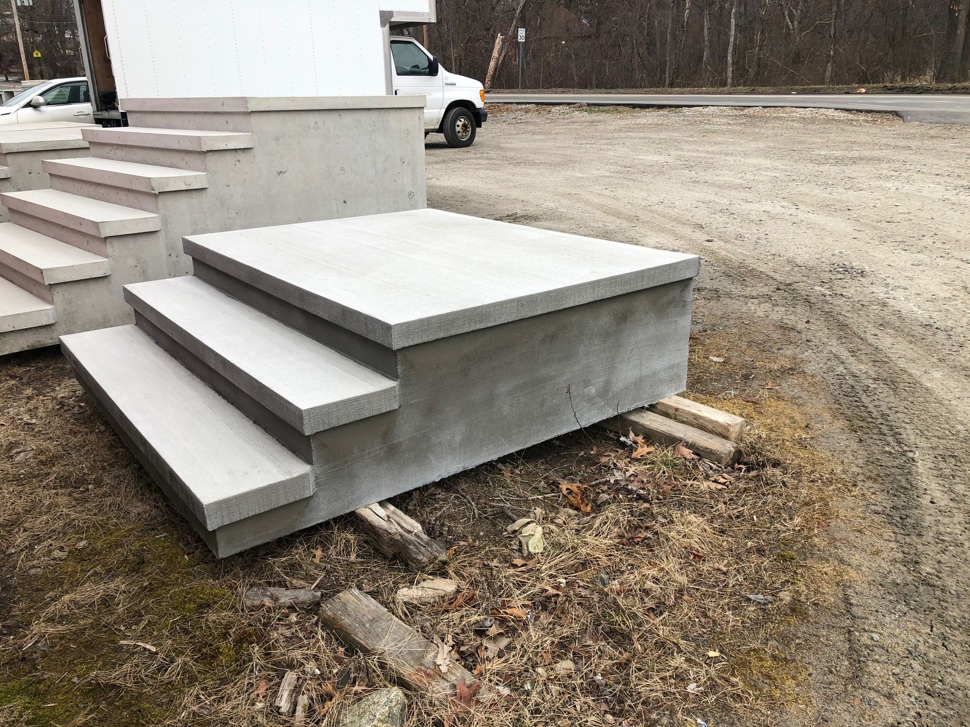 A set of concrete steps sitting on top of a dirt field.