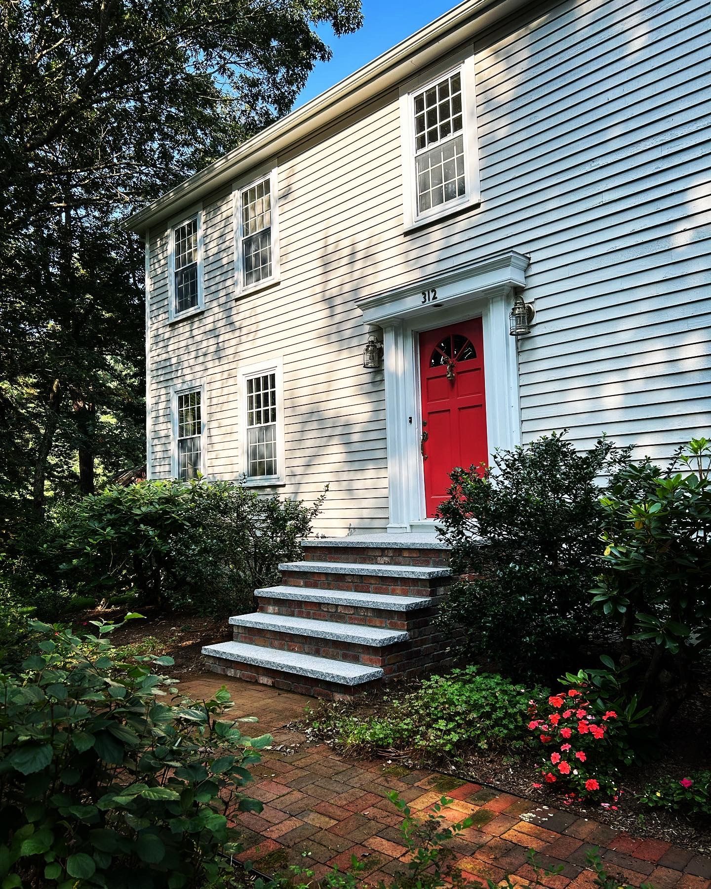 A white house with a red door and stairs