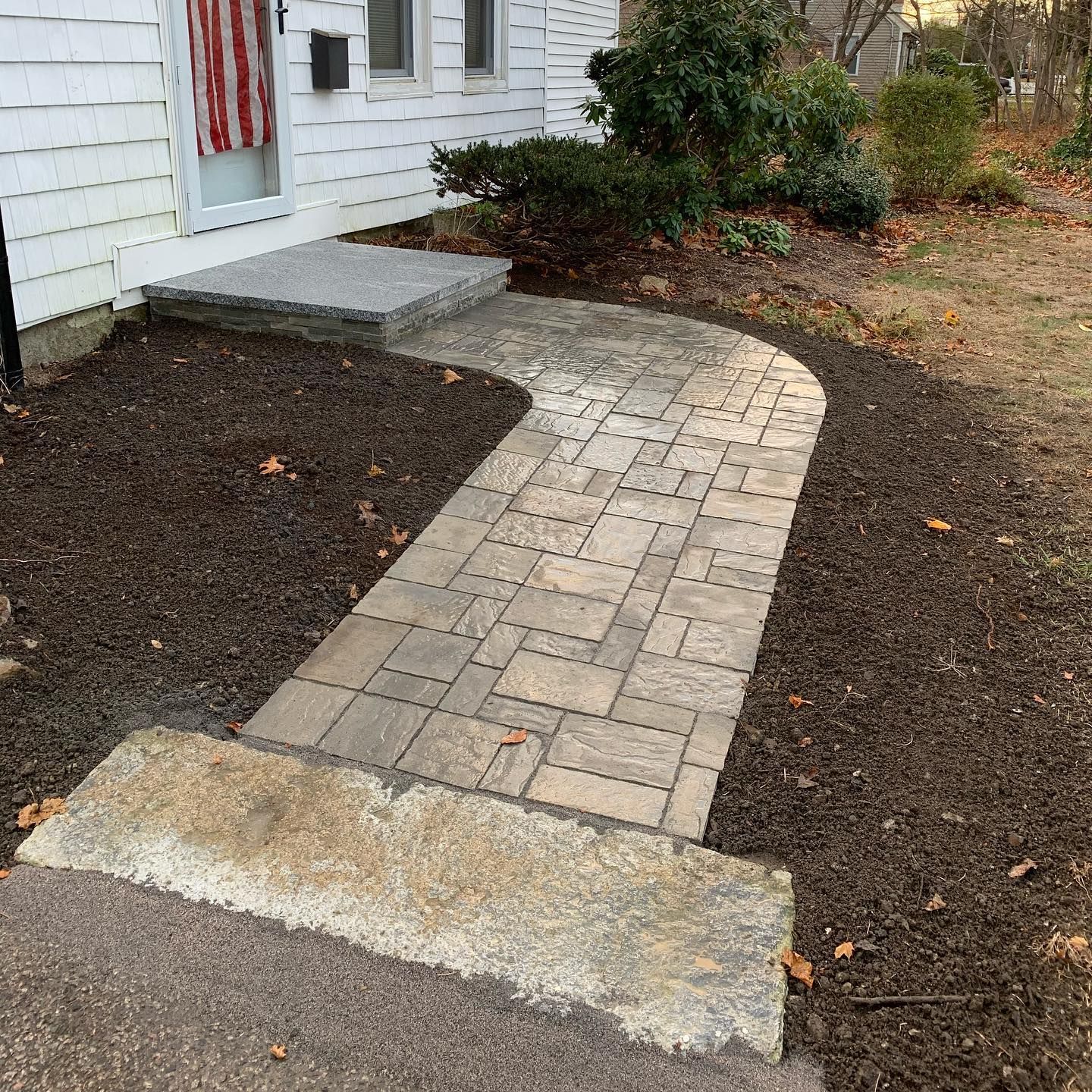 A brick walkway leading to the front door of a house.