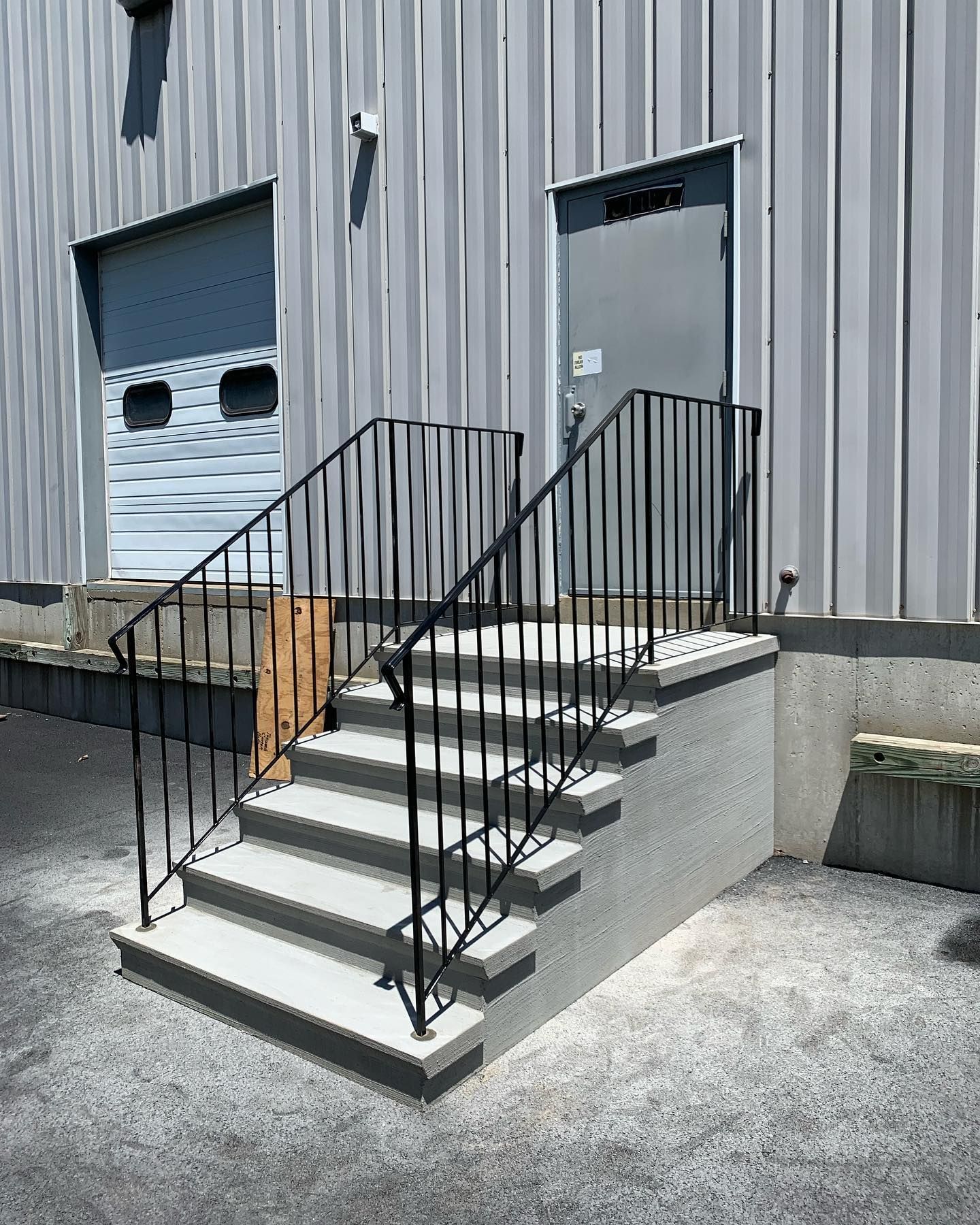 A set of stairs leading up to a building with a metal railing.