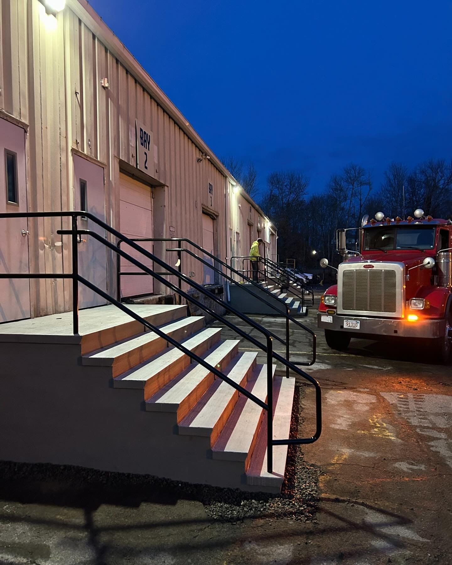 A red truck is parked in front of a building at night