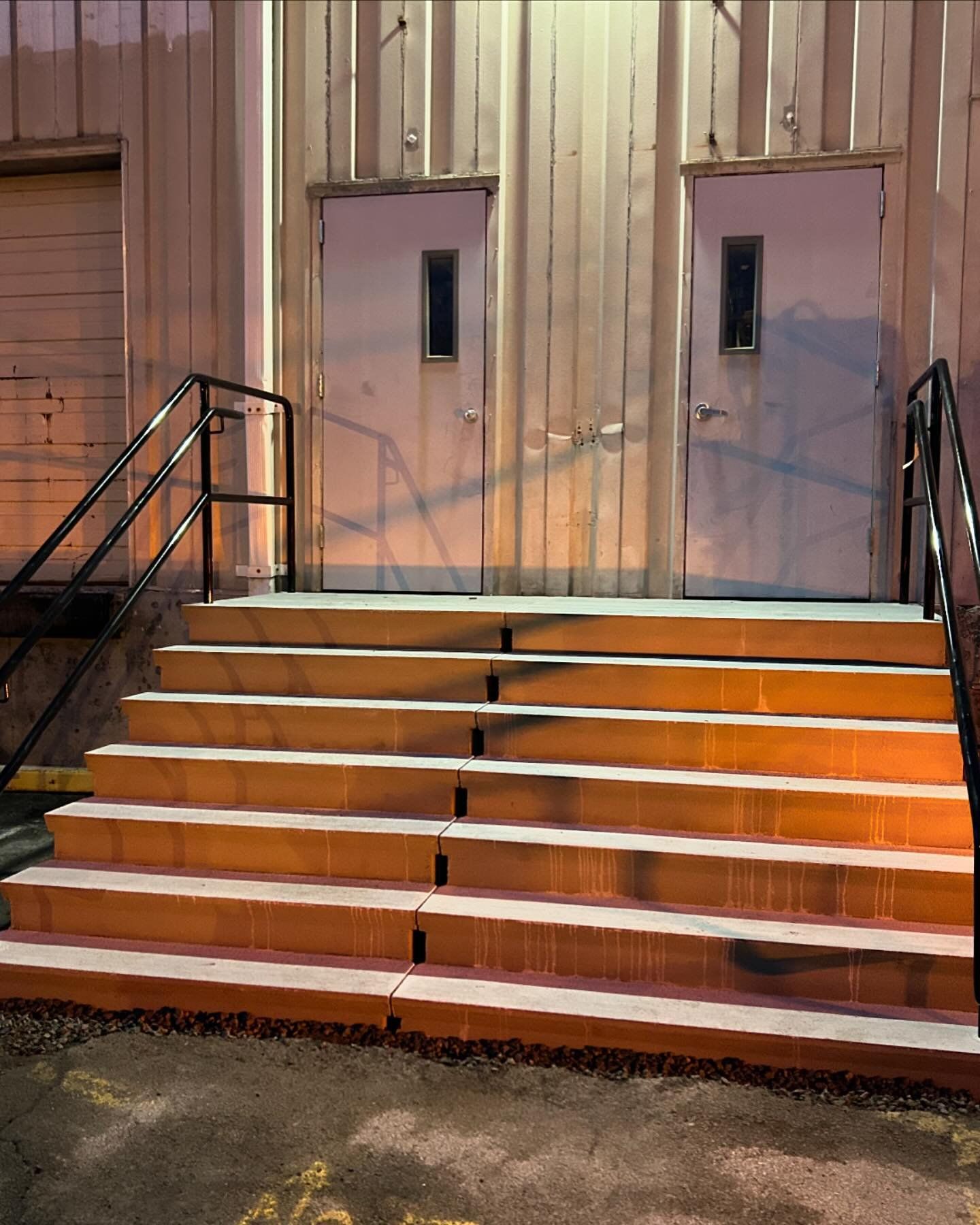 A set of stairs leading up to a building with two doors