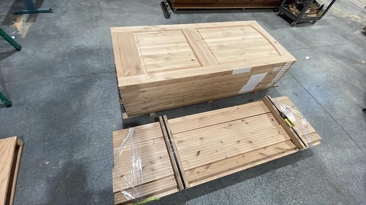 Two wooden crates, one large, closed, and the other smaller, disassembled on a concrete floor in a workshop.