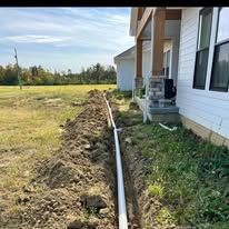 A drain pipe is being installed in front of a house.