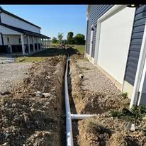 A drain pipe is being installed on the side of a house.