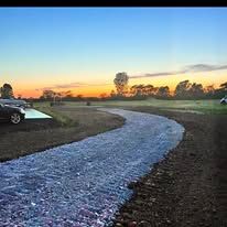A car is parked on the side of a gravel road.