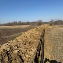 A large pile of dirt is sitting in the middle of a field.