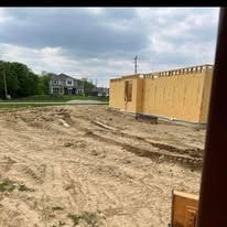 A house is being built in the middle of a dirt field.