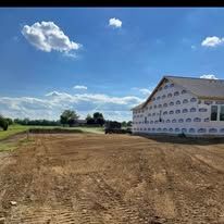 A house is being built in the middle of a dirt field.