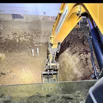 A yellow excavator is digging a hole in the ground.