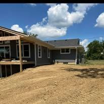 A house is being built on top of a dirt hill.