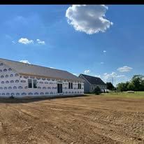 A house is being built in a dirt field.