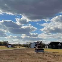 There is a bulldozer in the middle of a dirt field.