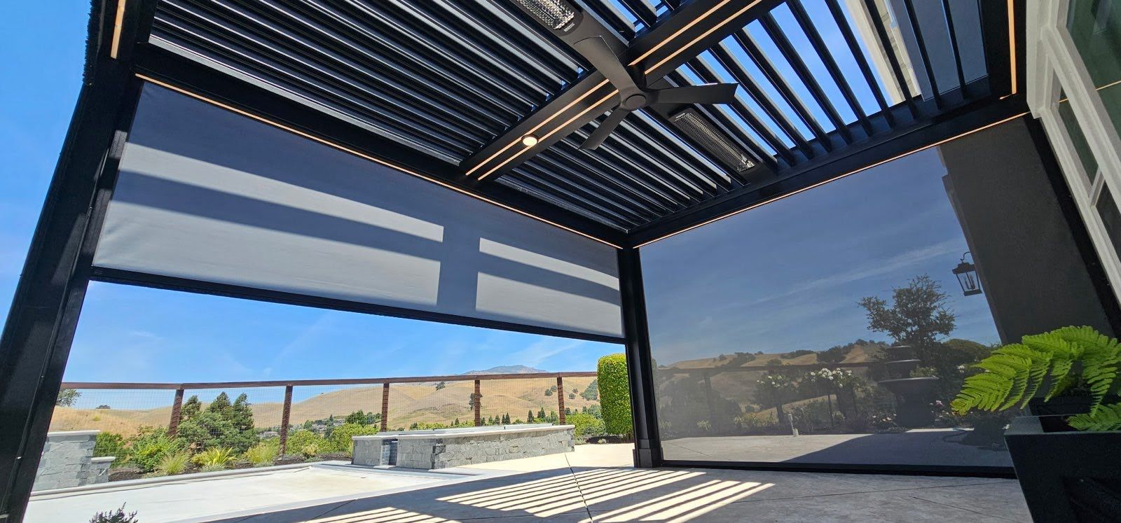 Modern patio with striped pergola shade, open view, and pool beside beige walls under blue sky