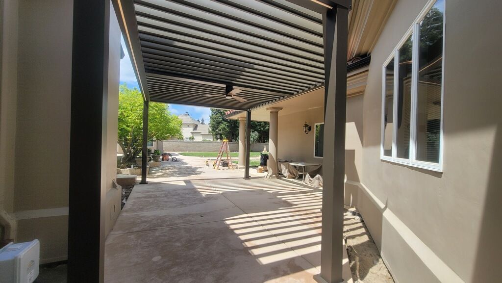 There is a pergola on the side of the house.
