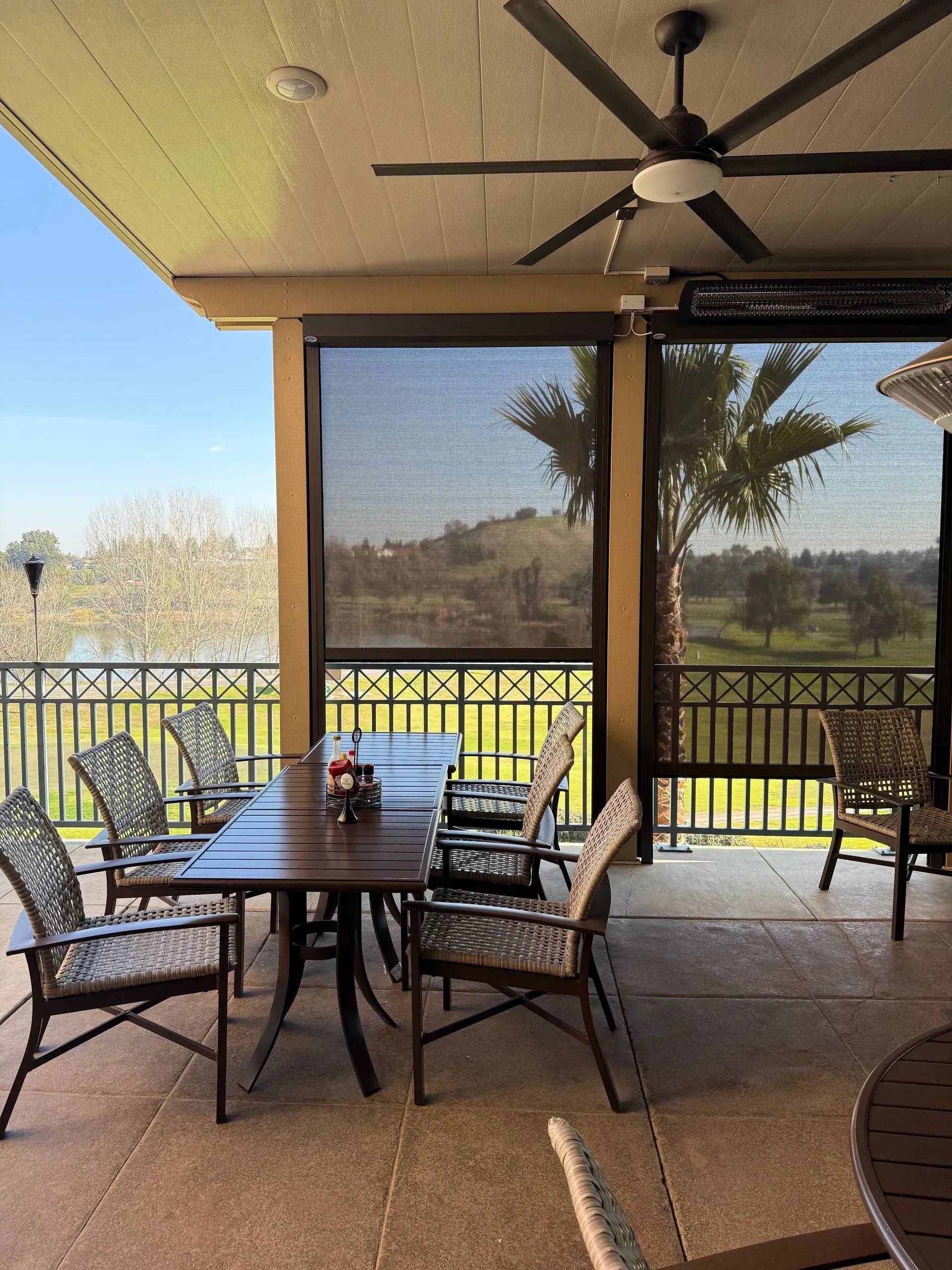 A patio with a table and chairs and a ceiling fan