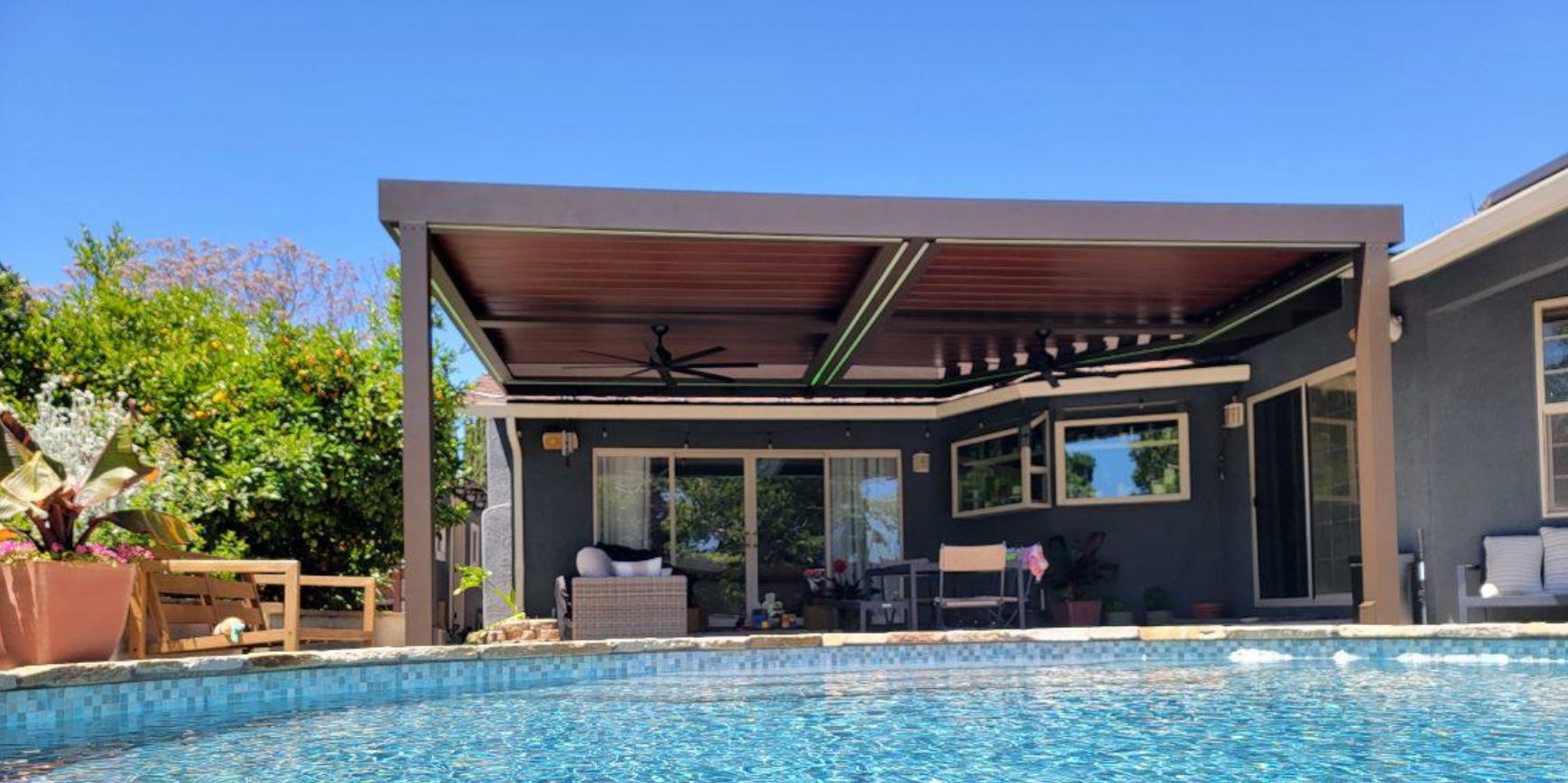 A house with a swimming pool and a pergola over it.