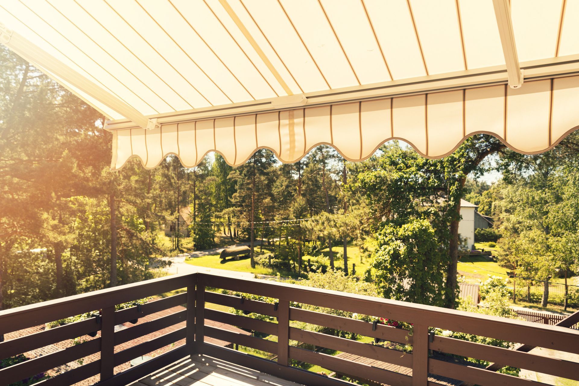 A balcony with a canopy over it and trees in the background