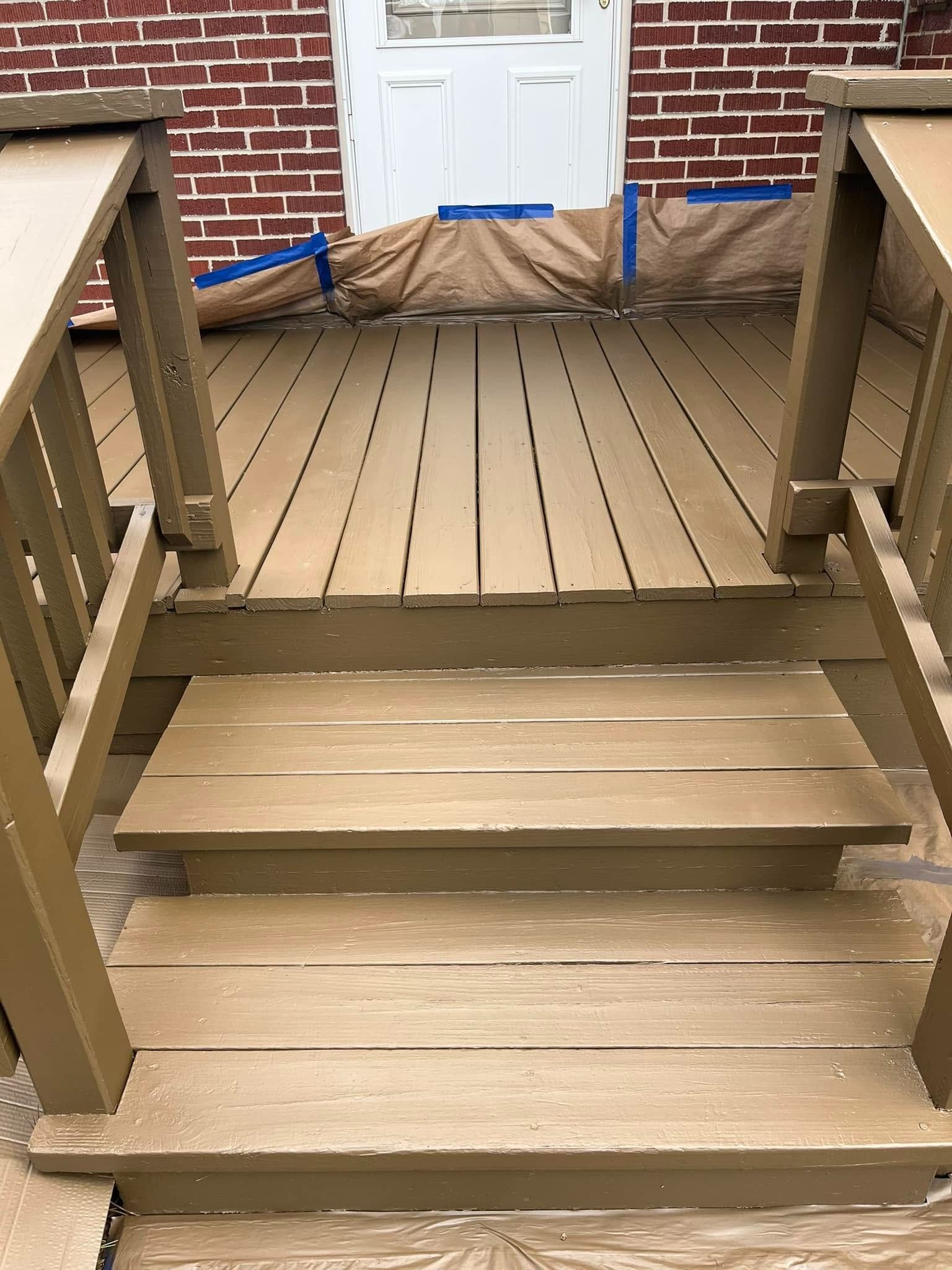 Front steps leading to a wooden porch with white door and brick wall, showing uneven stair heights