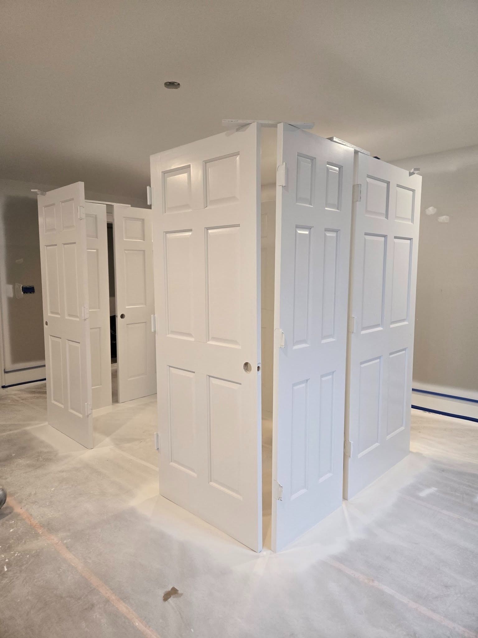 White built-in closet doors in a newly painted room under construction.