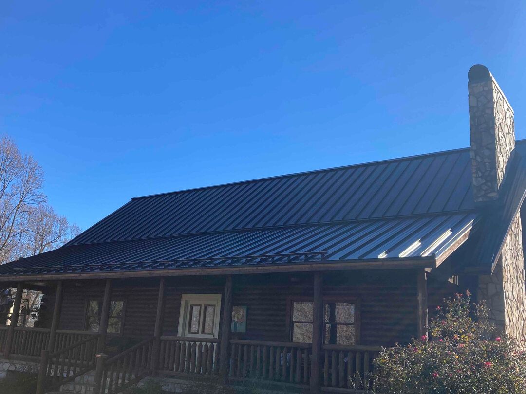 a log cabin with a metal roof and a chimney .