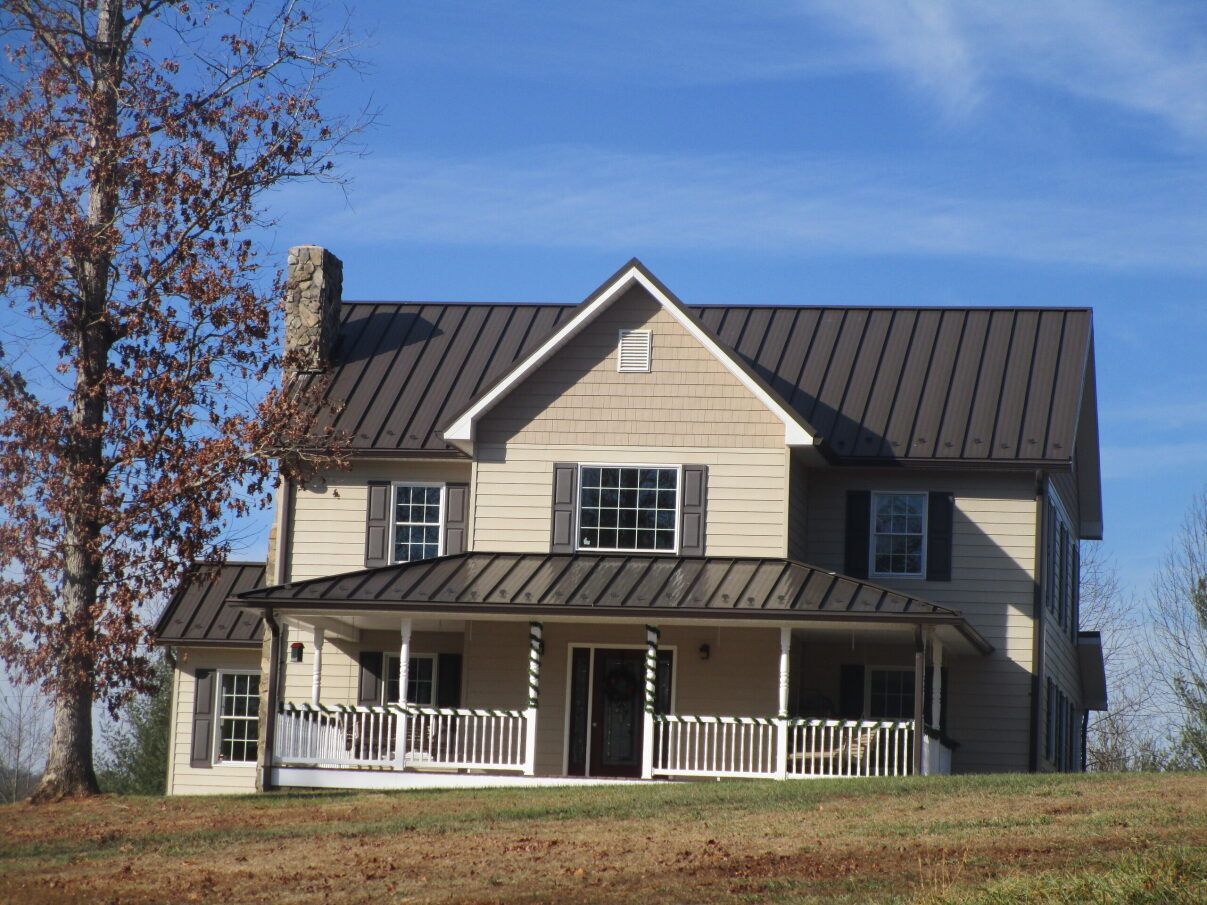 a large house with a brown roof and a large porch